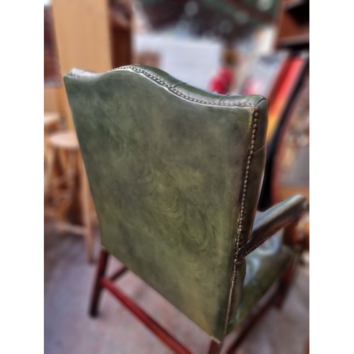 562 - Star Lot : A very handsome Chesterfield open armchair of generous proportions. With a curved wooden ... 