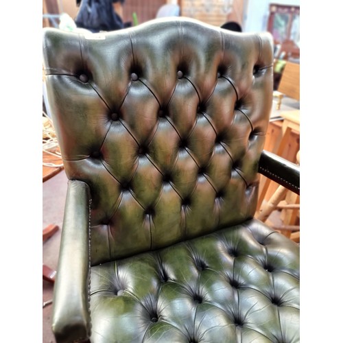 562 - Star Lot : A very handsome Chesterfield open armchair of generous proportions. With a curved wooden ... 