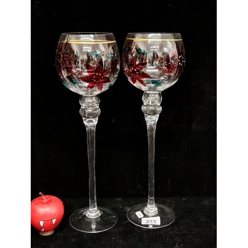 253 - A pair of very large festive Christmas ornamental glasses with hand painted poinsettia motif through... 