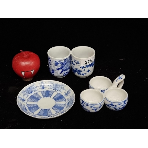 275 - Four pieces of Chinese porcelain including two tea cups, a condiment dish and a saucer, all in blue ... 