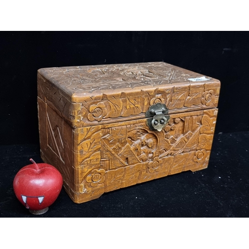 281 - A charming large vintage hand carved wooden box featuring figurative and floral motifs with brass cl... 