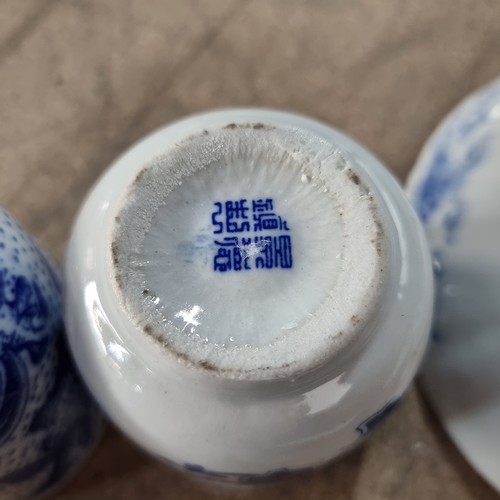275 - Four pieces of Chinese porcelain including two tea cups, a condiment dish and a saucer, all in blue ... 