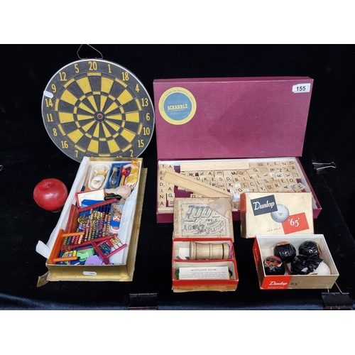 155 - A selection of vintage toys and game pieces including a cork dartboard, dollhouse abaci, four Dunlop... 