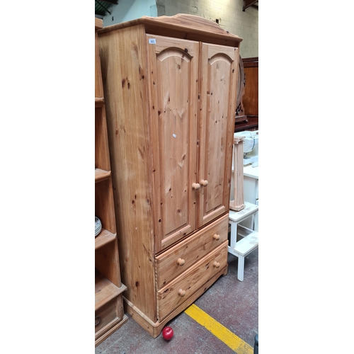 485 - A solid pine wardrobe with two doors to front, clothes rail inside and two drawers to base for ample... 