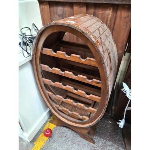 488 - A fabulous oval wooden wine rack with slat wood exterior and space for 19 bottles of wine.