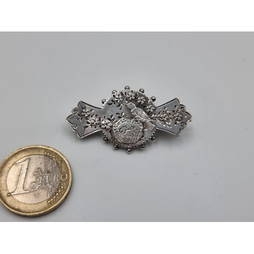 510 - A beautiful sterling silver antique sweet heart brooch, which features an intricate scene of a conte... 