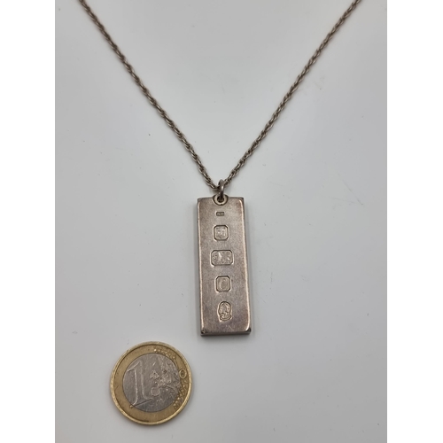 514 - A sterling silver ingot and chain, hallmarked London. With an attractive sun burst machine finish to... 