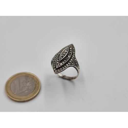 525 - A striking Marcasite graduated ring, with intricate shoulders and set in sterling silver. Ring size:... 