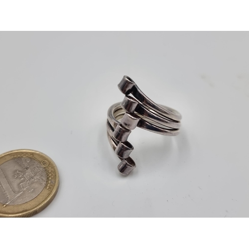 527 - A Modernist striking six stand sterling silver ring. Size: Q. Weight: 8.6 grams.