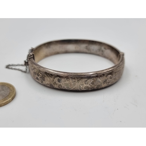 534 - A pretty vintage sterling silver bangle with foliate motif through out and attached safety chain. We... 