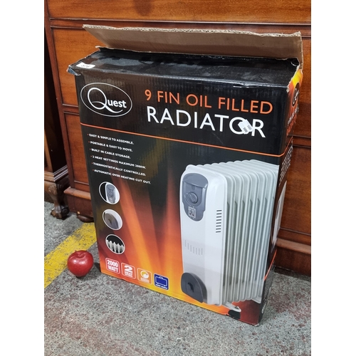 576 - A new in box Quest 9 fin oil filled radiator with two heat settings and 2000 watts power. A smaller ... 