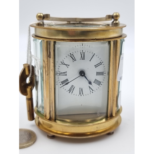 817 - A fine example of a brass carriage clock, featuring a white enamel face and roman numeral dial. This... 