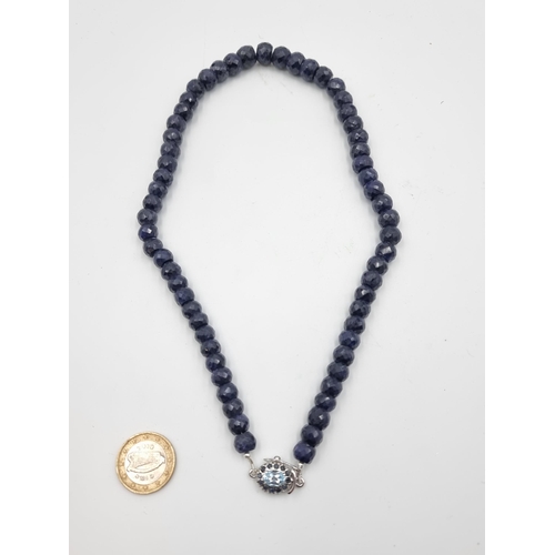 825 - A beautiful facet cut Sapphire graduated necklace, set with a striking Topaz clasp and Sapphire ster... 