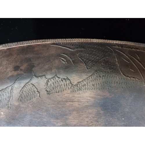 141 - A very large, lathe turned. African wooden bowl. With incised detail featuring elephant and rhinocer... 