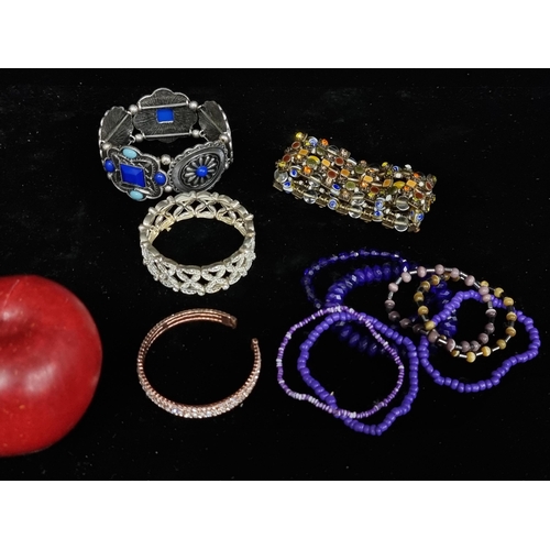 175 - A selection of eleven costume jewellery bracelets including a number of purple beaded examples with ... 