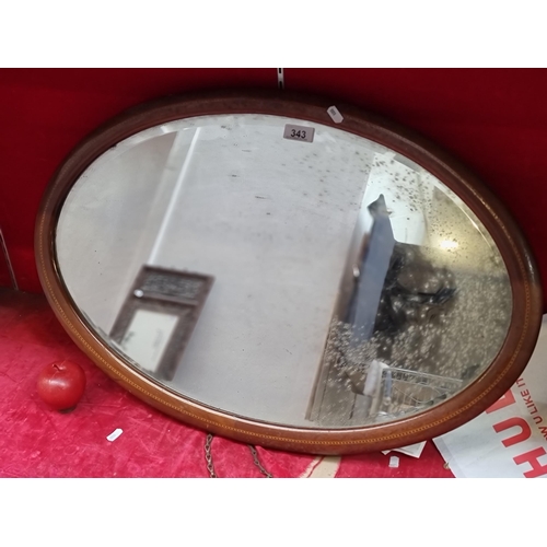 343 - A large, vintage oval bevelled mirror with a nicely inlaid wooden frame, and wall mountable. H49cm x... 