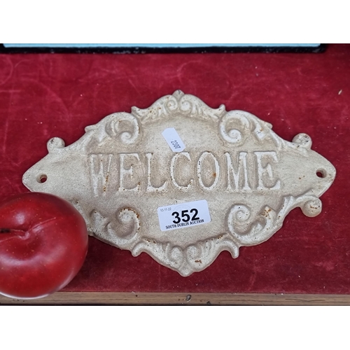 352 - A cast metal Welcome plaque with lovely scroll detail, in a cream finish. Can be mounted on a wall.