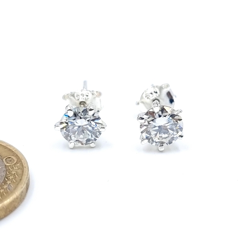 47 - A sparkling and bright pair of Solitaire Moissanite stud earrings, set in sterling silver with butte... 