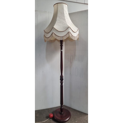 635 - A handsome vintage fllor lamp, with turned wooden stem and finished with a cream fringed shade.