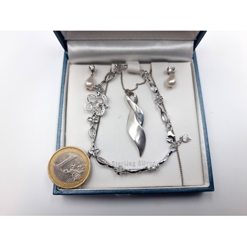 657 - A suite of sterling silver jewellery, consisting of a pendant and chain, a gem set bracelet and a ge... 