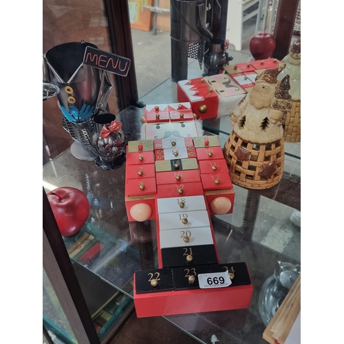 669 - Three items including a Nutcracker shaped wooden advent calendar with little drawers for each day le... 