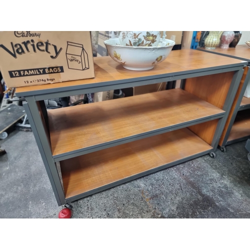 682 - A high quality commercial storage trolley with three shelves and push handles to side held on castor... 