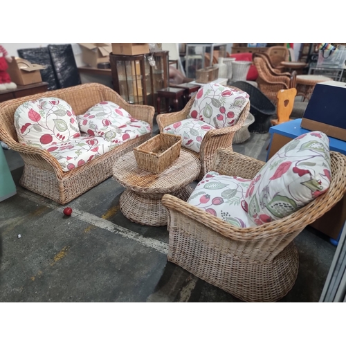 705 - A delightful four piece cane wicker suite including two armchairs, a two seater sofa and a coffee ta... 