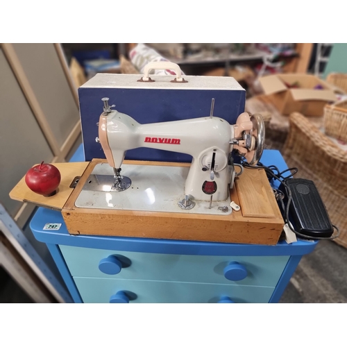 716 - A vintage Novem Mark III sewing machine, made in Ireland. On a wooden base with accompanying foot pe... 