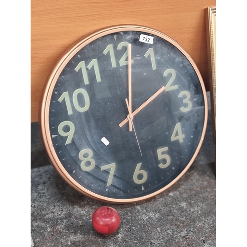 732 - A very large battery operated, wall mountable clock with uranium style numerals in a copper toned be... 