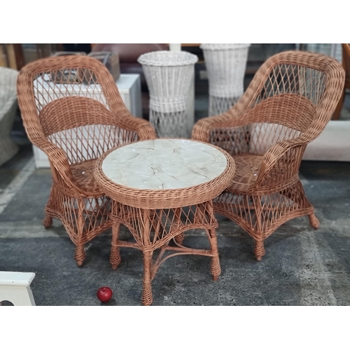 744 - A charming wicker  set of two armchairs and a round table with marble effect top.