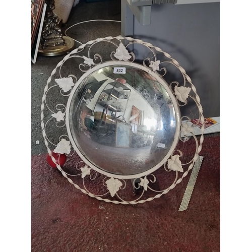 832 - A vintage  wall convex mirror, featuring a worked metal surround which includes pretty ivy leaf moti... 