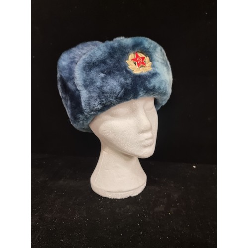 494 - A very warm ushanka hat with a Russian military pin and deep turquoise lining.