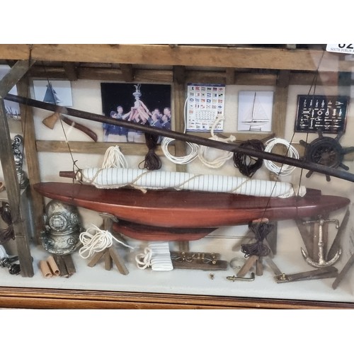 821 - A fantastic and highly detailed naval box frame diorama display, featuring a lifeboat, diving helmet... 