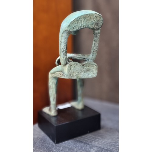 675 - A fabulous heavy cast bronze sculpture of a stylised figure, suspended in a slumped seated pose, sup... 