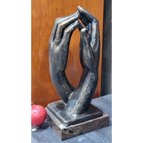 674 - A stuning remarkaby heavy cast bronze elegant sculpture of two hands touching, supported by a wooden... 