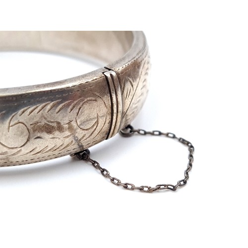 404 - A delightful sterling silver bangle bracelet with incised foliate ornament. Weight: 30.71 g.