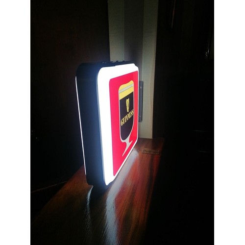 364 - A neatly sized double sided light-up sign, advertising Guinness in shades of red, black and white. W... 