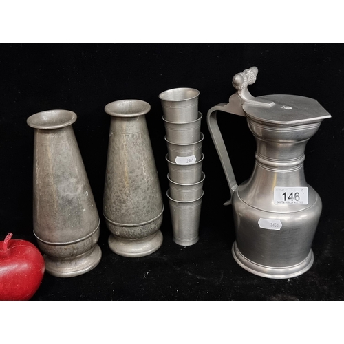 146 - A selection of nine pieces of vintage pewter. Including a pair of hand hammered bud vases by Abbey P... 