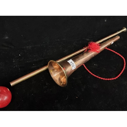 172 - Along  brass and copper hunting horn. A modular two-piece horn with original red cord.