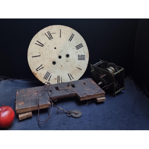 324 - An antique Georgian wall clock, with a heavy brass mechanism and cream face with crazing. Featuring ... 