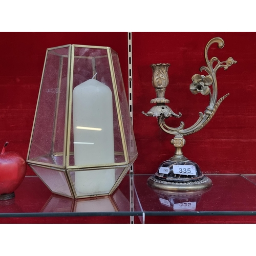 335 - Two contrasting candle display items. including a highly ornate brass candlestick with foliate scrol... 