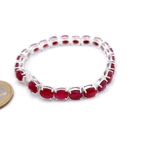 414 - An Oval Ruby tennis bracelet, of 20 grams and set in sterling silver. A beautiful tennis bracelet Wi... 