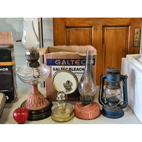 725 - A selection of four antique kerosene lamps, including an Edwardian example with a coral stem and com... 