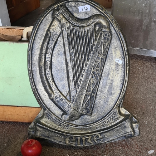 735 - A very heavy large plaster wall plaque depicting the national symbol of a harp in an ovular border, ... 