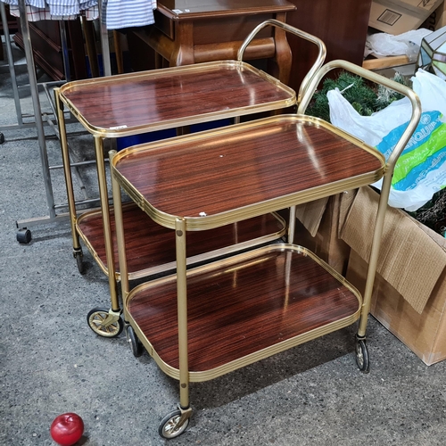 784 - Two genuine 1960s drink's trolleys. With brass toned frames and large original wheels. Both very cle... 