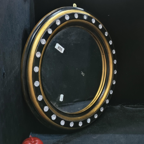 855 - A circular wall mirror with gilt and black wooden frame and inlaid diamante to give a porthole effec... 