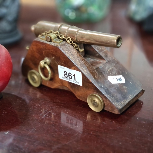 861 - A charming and striking copper desktop cannon with brass fittings and mounted on a wooden base featu... 