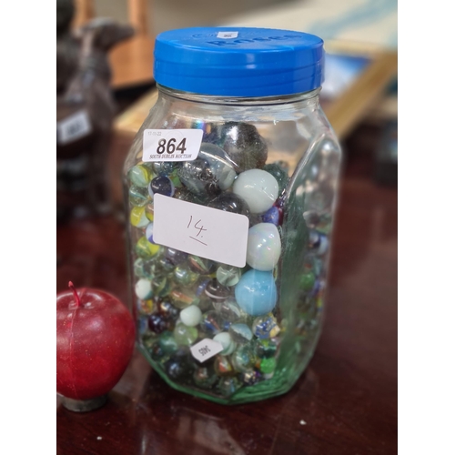 864 - A large glass jar containing a considerable quantity of vintage glass marbles, including milk glass ... 