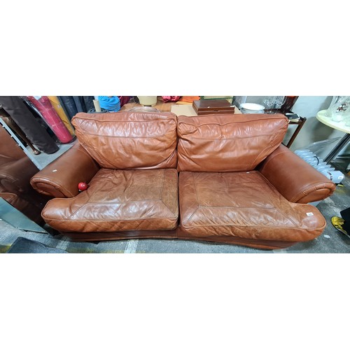 840 - A handsome masculine three seater sofa upholstered in genuine tan leather. A very cosy and comfortab... 