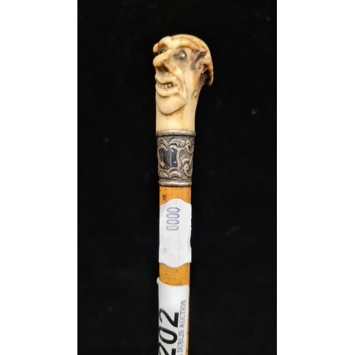 202 - An antique swagger stick, with a fantastic carved horn figural finial. A very unusual and comedic ex... 